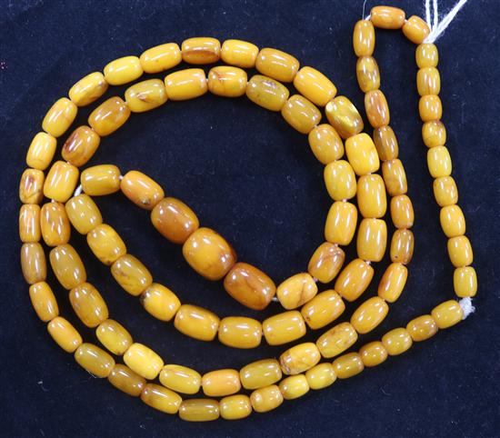 A single strand graduated barrel shape amber bead necklace, 86cm.